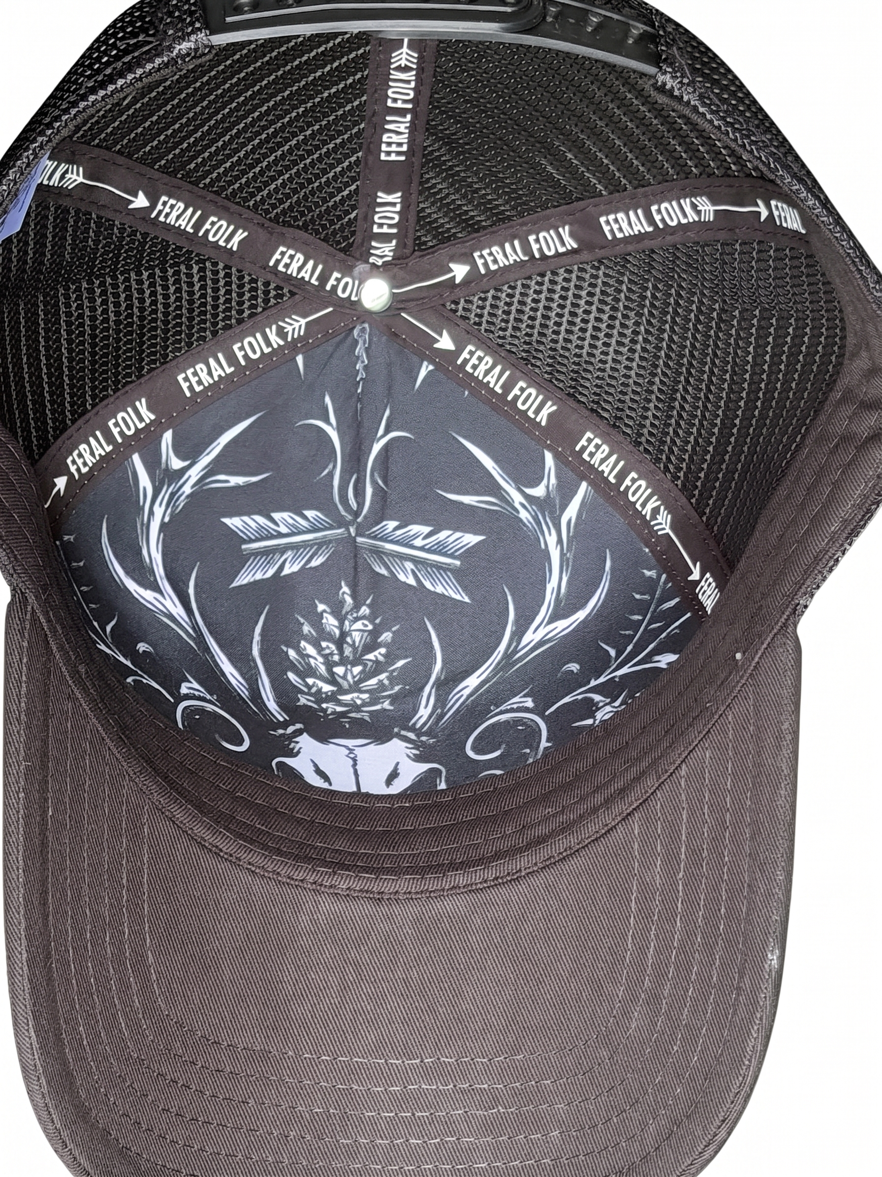 Black cap with white skull design and 'Feral Folk' branding on a white background