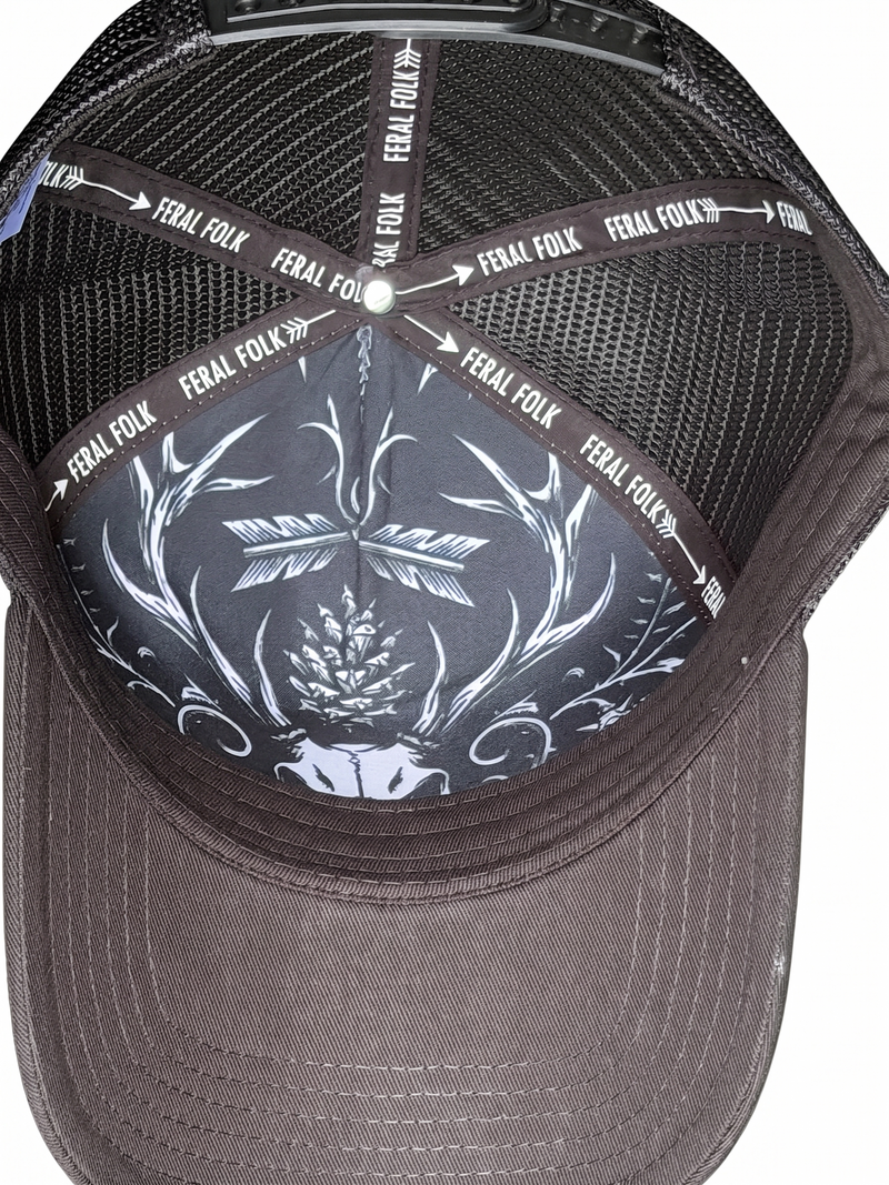 Black cap with white skull design and 'Feral Folk' branding on a white background