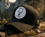 Black and brown cap with 'Feral Folk' logo on a natural background