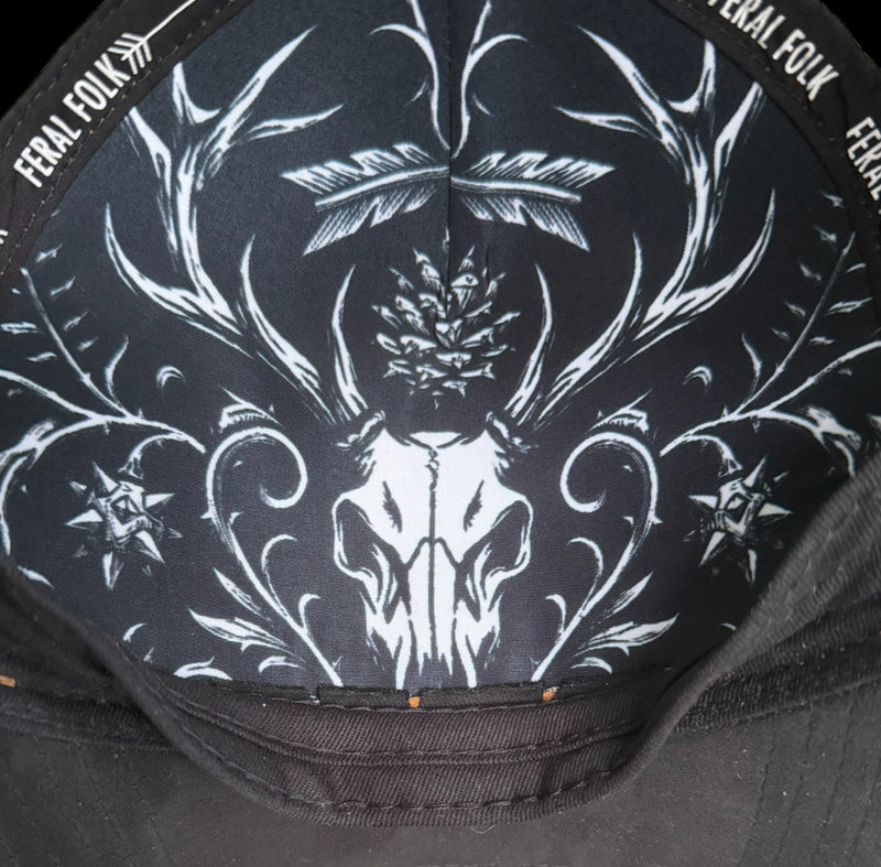 inside lining of a cap with white deer skull and antlers design, branded 'FERAL FOLK'.