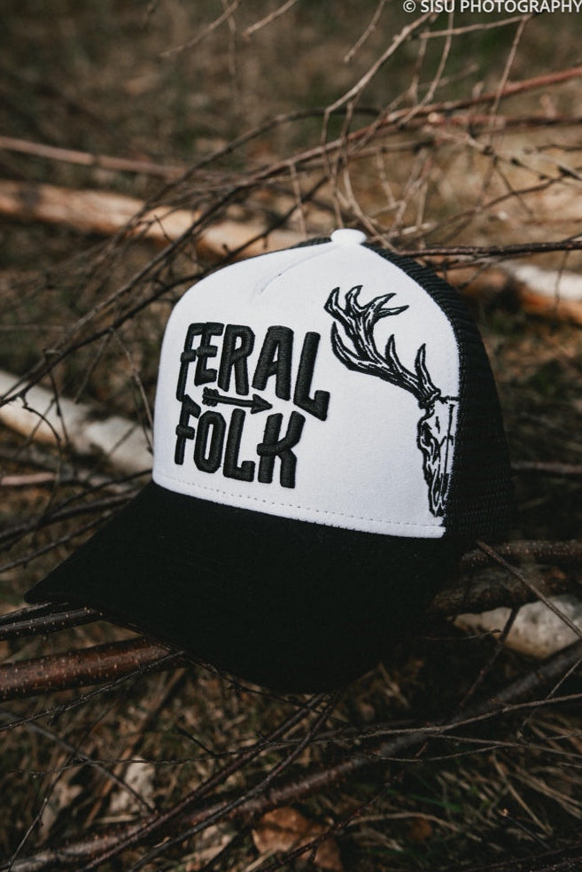 Black and white cap with 'Feral Folk' text and deer design on branches