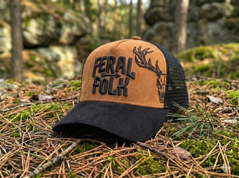 Cap with 'Feral Folk' text and deer design on a forest floor background