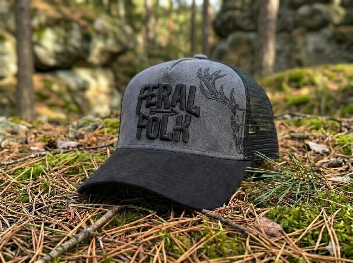Gray and black cap with 'Feral Folk' text on a forest floor background