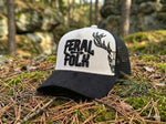 Black and white cap with 'Feral Folk' text and deer design on a forest floor.